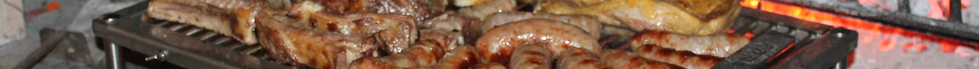 Griglia in acciaio inox con carne, salsicce e pollo arrostiti su braci ardenti