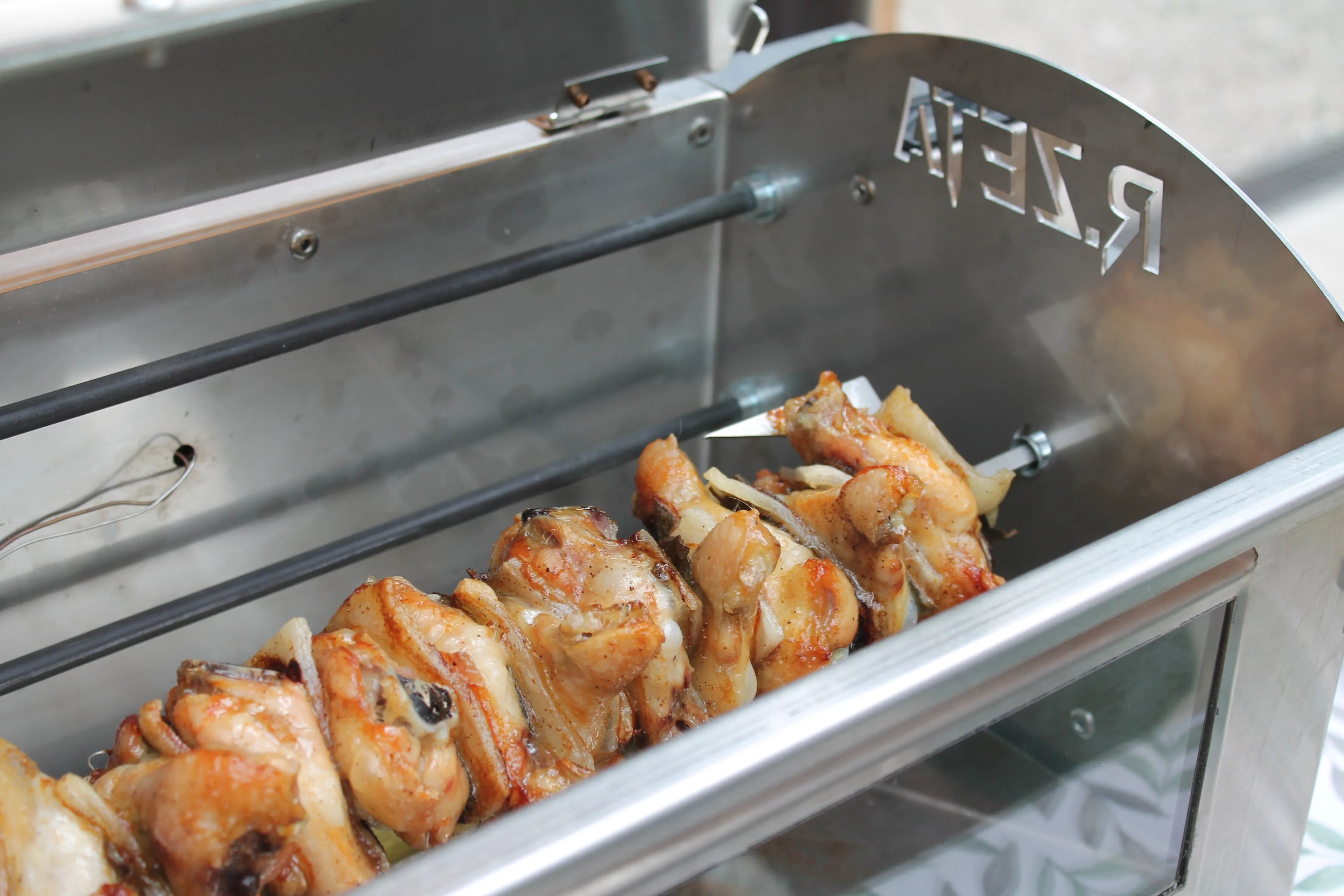 Pollo arrosto su girarrosto in acciaio inox per barbecue e cucina professionale