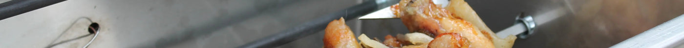 Pollo arrosto su girarrosto in acciaio inox per barbecue e cucina professionale