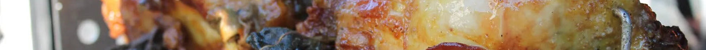 Polli arrosto su girarrosto in acciaio inox con fiamme e fumo, ideale per barbecue all'aperto