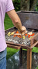 Barbecue a carbone con griglia in acciaio, ideale per grigliare carne e verdure all'aperto.