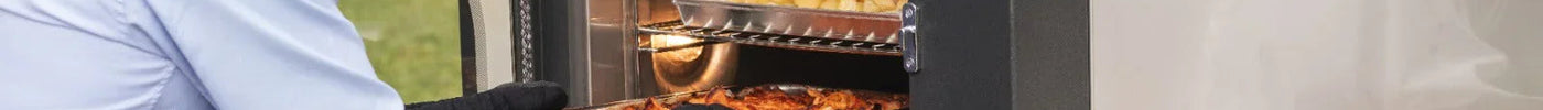 Uomo che cuoce cibo in un barbecue professionale in acciaio inox all'aperto