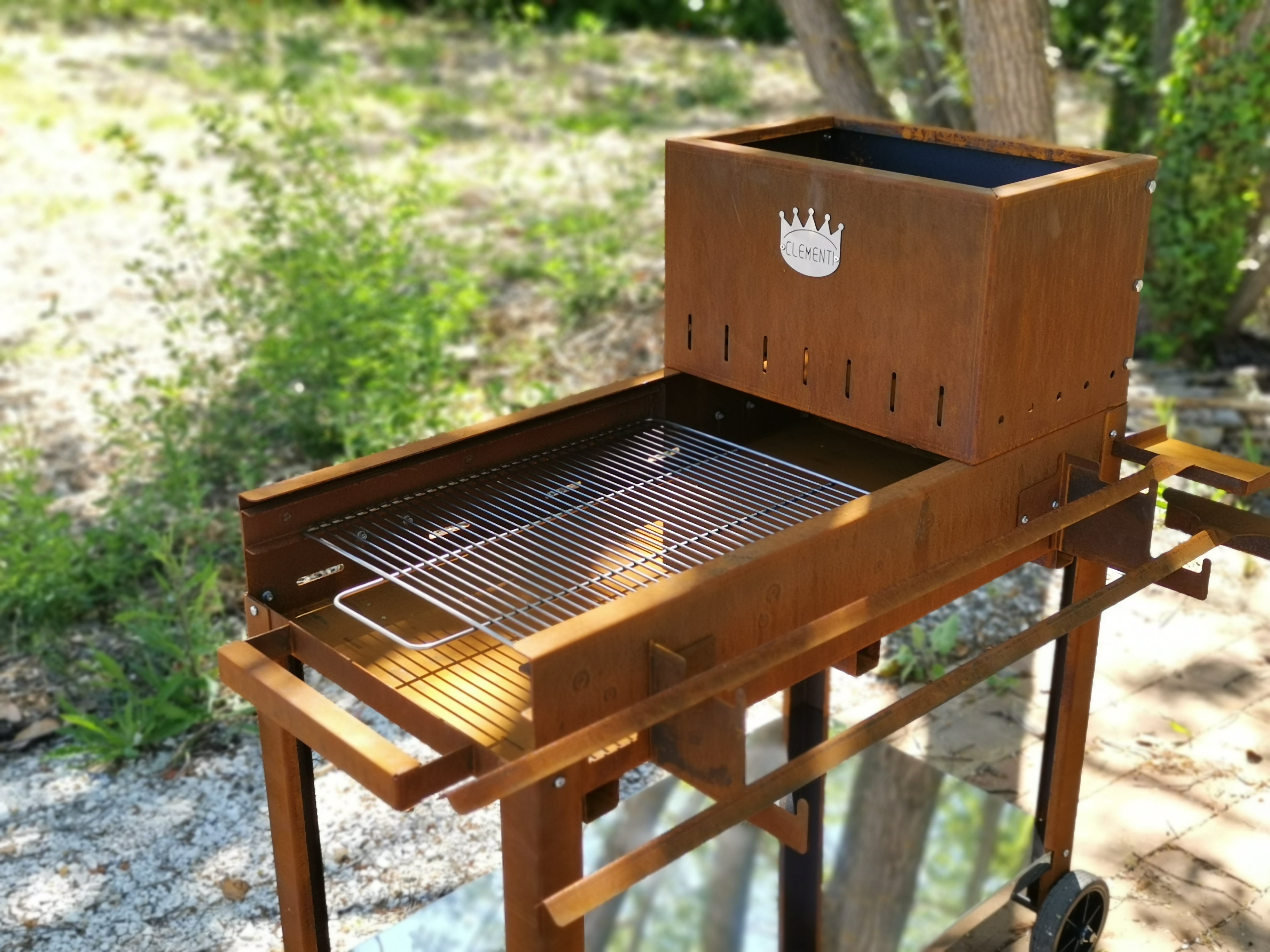 Barbecue in acciaio inox con griglia e logo 'CLEMENT' per cucina all'aperto
