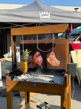 Barbecue in acciaio inox con carne e ananas arrostiti su carboni