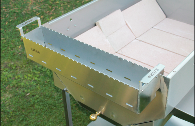 Barbecue in acciaio inox RZeta con griglia e mattonelle refrattarie, ideale per cucina all'aperto.