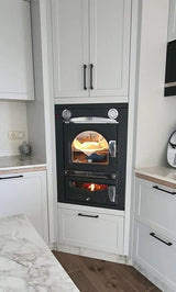 Forno a legna Clementi Smart da incasso integrato in cucina moderna — fiamma visibile